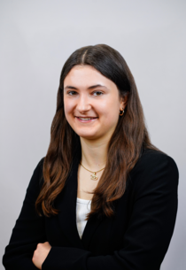 Porträtfoto eines weiblichen Teammitglieds mit langen braunen Haaren.